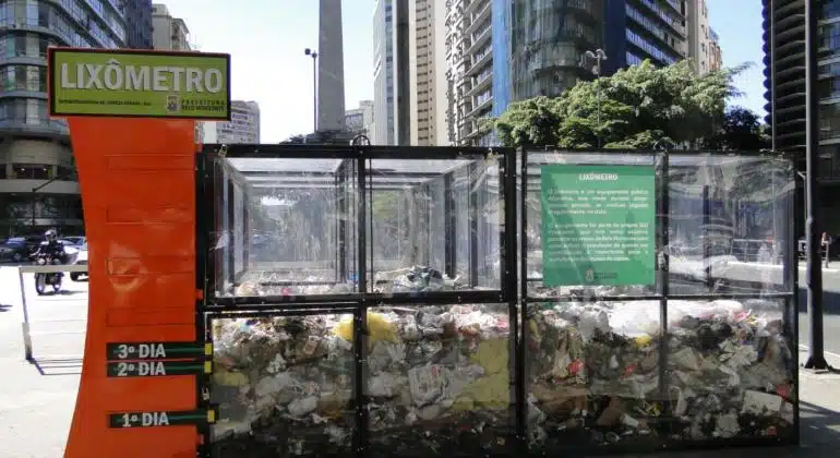 'Lixômetro' é instalado em BH para conscientizar moradores sobre limpeza O objetivo é conscientizar a população sobre a conservação da cidade, sensibilizando as pessoas que transitam pelo Centro sobre a importância de colaborar com a limpeza, principalmente não jogando lixo no chão. A região da Praça Sete é varrida pela Superintendência de Limpeza Urbana (SLU) diariamente, inclusive aos sábados, domingos e feriados, quatro vezes por dia, no mínimo. Nos quarteirões fechados da praça existem 90 lixeiras. Mesmo assim, o local não permanece limpo por muito tempo. Entre os resíduos mais comuns, descartados de forma inadequada, estão papel, embalagens plásticas, pontas de cigarro, garrafas de vidro e restos de alimentos. “O Lixômetro vai mostrar que um simples papel de bala jogado no chão, somado a tantos outros pequenos resíduos, se transforma rapidamente em uma montanha enorme de lixo”, destaca a chefe do Departamento de Limpeza Urbana da SLU, Erika Resende. Ela acrescenta que sem a colaboração da população, o esforço dos garis na varrição não é suficiente. “A intenção do Lixômetro é que todos percebam, literalmente, o tamanho do problema que representa o lixo jogado nas ruas e a importância de todos colaborarem com a limpeza da cidade”. Além da varrição praticamente o dia todo na praça, a coleta de resíduos domiciliares no Hipercentro também é feita diariamente, no período noturno. A capina é realizada seis vezes por ano. Regularmente, a SLU retira adesivos e cartazes de 1,5 mil postes, mensalmente. Também faz a lavação de mais de cem pontos considerados críticos diariamente, inclusive aos domingos, onde há uma grande concentração de pessoas circulando. Ao longo da próxima semana, a equipe de Mobilização Social da SLU abordará comerciantes e pedestres, com orientações sobre os serviços de limpeza disponíveis na região. Como colaborar com a limpeza urbana no centro de BH: - Não jogue lixo ou entulho no chão. Além de poluir a cidade, o lixo nas ruas entope bocas de lobo e pode provocar enchentes. - Respeite os dias e horários de exposição do lixo para coleta, evite deixar seu lixo na rua por mais tempo que o necessário. - Embale corretamente seu lixo, em sacos resistentes, bem fechados e de tamanho adequado, para evitar que eles se abram e o lixo seja espalhado nas vias públicas. Lixo não embalado, além de exalar mau cheiro, atrai animais que podem ser portadores de doenças. - Embale o vidro e outros materiais perfurocortantes (estiletes, pregos, lâminas) com material resistente antes de colocá-lo no saco de lixo, e pressione as tampas das latas para dentro. Esses materiais desprotegidos podem ferir o gari, mesmo ele usando luvas protetoras. O gari acidentado pode ter que se afastar do trabalho e a coleta em sua região poderá ficar prejudicada. - No trânsito, respeite os cones de sinalização, usados para proteger os varredores, que estão trabalhando para deixar a cidade mais limpa para todos.